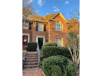 Charming brick townhome with manicured landscaping and symmetrical windows under a blue sky at 1271 Whitlock Ridge Sw Dr, Marietta, GA 30064