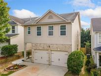 Charming two-story home with a brick-accented two-car garage and manicured front yard at 305 Hidden Creek Ln, Canton, GA 30114