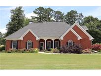 Charming brick home with well-maintained landscaping and inviting front lawn at 405 Mallory Cir, Loganville, GA 30052