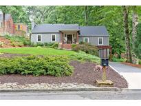 Charming home featuring manicured lawn, gray siding, and a cozy front porch with seating at 3072 Dale Ne Dr, Atlanta, GA 30305