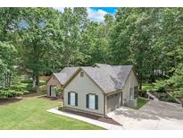 Well-maintained home featuring neutral siding, black shutters, and an attached garage in a lush, green setting at 2105 Huntington Hills Trce, Buford, GA 30519