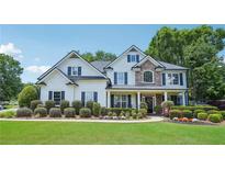 Inviting two-story home featuring manicured landscaping, a stone accent wall, and classic black shutters at 4365 Mantle Ridge Dr, Cumming, GA 30041