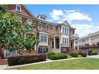 Charming townhome with a well-maintained lawn, manicured bushes, brick and stone facade, and inviting front entrance at 4874 Seldon Se Way, Smyrna, GA 30080