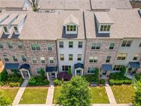 Charming brick townhomes with landscaped front yards and inviting entrances, showcasing a desirable community at 20057 Windalier Way, Roswell, GA 30076