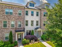 Beautiful brick and painted townhome with a manicured front yard and attractive landscaping at 20057 Windalier Way, Roswell, GA 30076