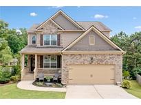 Charming two-story home with a brick and siding exterior, well-manicured lawn, and attached two-car garage at 432 Providence Walk St, Canton, GA 30114