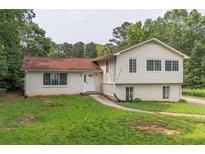 Charming split-level home featuring a brick facade, red roof, and a spacious front yard at 4408 Shiloh Trl, Powder Springs, GA 30127