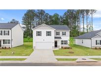 Charming two-story home featuring a two-car garage and beautifully maintained landscaping at 1622 Palladian Way, Lithonia, GA 30058