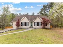 Charming single-story home with manicured lawn, mature trees, and a welcoming walkway at 195 Blackberry Run, Fayetteville, GA 30214