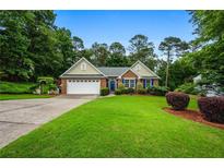 Charming single-Gathering home featuring a well-manicured lawn and a two-car garage at 3770 Wake Robin Way, Cumming, GA 30028