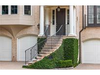 Elegant home entrance featuring a curved staircase with wrought iron railings and lush greenery at 92 Old Ivy Ne Rd # 6, Atlanta, GA 30342