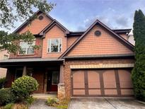 Charming two-story home with brick and shingle exterior, showcasing a well-manicured front yard and a two-car garage at 2532 Gloster Mill Drive Southwest, Lawrenceville, GA 30044