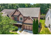 Charming two-story home featuring cedar-shake siding, a brick-accented garage, and a well-manicured front lawn at 2532 Gloster Mill Drive Southwest, Lawrenceville, GA 30044