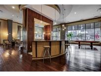 Modern lounge area featuring a bar, hardwood floors, and large windows overlooking the outdoor space at 3040 Peachtree Nw Rd # 1713, Atlanta, GA 30305