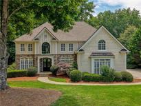 Charming two-story home with stone accents, manicured lawn, and lush landscaping creating an inviting curb appeal at 3795 Newport Bay Dr, Alpharetta, GA 30005