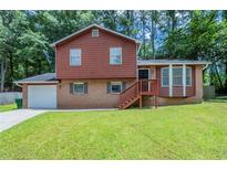 Charming two-story home with brick and wood exterior, front yard, and attached garage at 5207 Shawn Ln, Stone Mountain, GA 30088