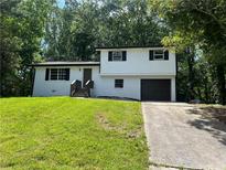 Charming two-story home featuring painted brick, a well-maintained yard, and an attached garage at 3800 Leisure Ln, Atlanta, GA 30349