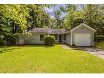 Charming single-story home with a well-maintained lawn, mature trees and an attached single car garage at 6200 Beaver Creek Trl, Atlanta, GA 30349