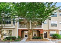 Charming townhome with brick accents, balcony, lush landscaping and inviting entryways at 213 Riverstone Commons Cir, Canton, GA 30114