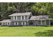 Charming two-story home featuring gray paint, white shutters, and a well-manicured lawn at 2849 Snapfinger Rd, Decatur, GA 30034