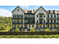 View of luxury townhomes with black framed windows, painted brick and beautifully manicured landscaping at 908 Catamaran Ct, Alpharetta, GA 30005