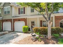 Charming two-story townhome with brick accents, attached garage, and landscaped front yard, offering curb appeal at 949 Pike Forest Dr, Lawrenceville, GA 30045