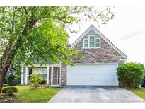 Charming stone front home featuring a two-car garage and well-manicured lawn at 2545 Lake Royale Dr, Riverdale, GA 30296