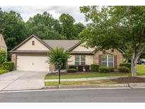 Charming single-story home with brick accents, mature landscaping, and a two-car garage at 1889 Raegan Way, Lawrenceville, GA 30043