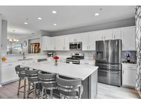 Bright kitchen with a large island, stainless steel appliances, and white cabinetry offers modern convenience at 11352 Musette Cir, Alpharetta, GA 30009