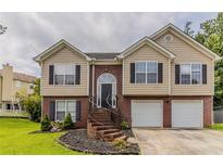 Charming split-level home with a brick facade, well-manicured lawn, and a two-car garage at 1006 Eagle Vw, Lawrenceville, GA 30044