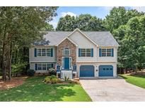 Charming two-story home featuring stone accents, blue shutters, and a well-manicured lawn at 327 Red Fox Dr, Canton, GA 30114