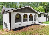 Charming home featuring a light-colored brick facade and lovely arched entryway at 3530 Turner Heights Dr, Decatur, GA 30032
