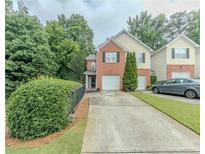 Charming two-story home with a brick facade, attached garage, and lush green landscaping at 1311 Primrose View Cir, Lawrenceville, GA 30044