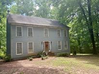 Charming two-story home with wood siding nestled among mature trees at 408 Hasty Trl, Canton, GA 30115