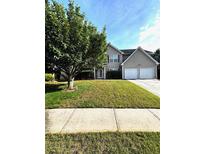 Traditional two-story home with a well-manicured lawn and a two-car garage at 7178 Glaspie Way, Atlanta, GA 30349