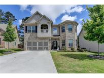 Beautiful two-story brick home with a well-manicured lawn and attached two-car garage at 2410 Melton Common Dr, Dacula, GA 30019
