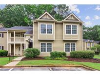 Inviting townhouse with a well-maintained lawn and manicured shrubs surrounded by mature shade trees at 67 Middleton Se Ct, Smyrna, GA 30080