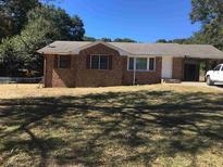 Charming brick home with a well-maintained lawn and a convenient carport at 6521 Menlo Way, Rex, GA 30273