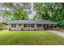 Charming brick home with a well-manicured front yard, carport, and cozy front porch at 2839 Long Way, Decatur, GA 30032