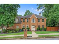 Charming two-story brick home featuring a manicured lawn and lush landscaping, and a welcoming front entrance at 200 Creek Run Ct, Alpharetta, GA 30005