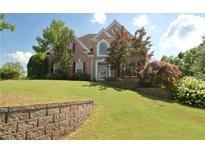 Brick two-story home with a landscaped front yard and retaining wall at 3071 Intrepid Wake, Marietta, GA 30062