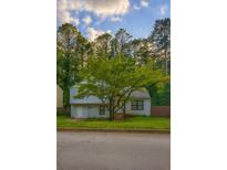 Charming two-story home features a well-maintained lawn and mature tree in front, with curb appeal at 4728 Garden Hills Dr, Stone Mountain, GA 30083