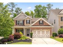 Charming brick two-story home with manicured landscaping and a three-car garage at 1220 Roswell Manor Cir, Roswell, GA 30076