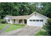 Charming single-story home with white siding, a well-manicured lawn, and an attached two-car garage at 2440 Weatherford Ct, Marietta, GA 30068