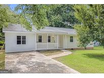 Charming single-story home with a covered front porch and a well-manicured lawn at 33 Russell Rd, Mcdonough, GA 30252