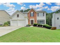 Charming two-story home with a well-manicured lawn, brick accents and an attached two-car garage at 3845 Lake Lanier Dr, Duluth, GA 30097