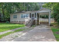 Charming single-story home with a stone foundation, front porch, and covered carport at 91 Tatum St, Marietta, GA 30060