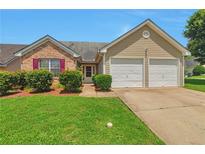 Charming home featuring a well-maintained lawn, brick accents, and a two-car garage at 420 Spring Lake Ter, Covington, GA 30016