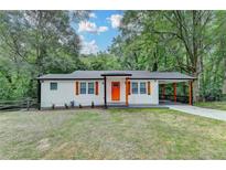 Charming renovated home with an orange front door, cedar shutters, and a covered carport at 737 Bolton Nw Rd, Atlanta, GA 30331
