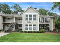 Inviting condo featuring well-maintained landscaping, a combination of siding and stone, and a large front lawn at 3210 Lake Pointe Cir, Roswell, GA 30075